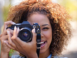 Woman taking picture with digital camera