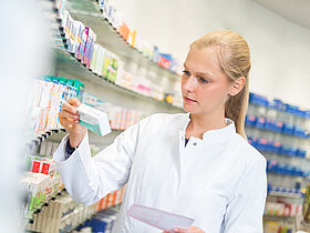 Apothekerin hält ein Rezept in der Hand