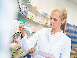 Apothekerin hält ein Rezept in der Hand