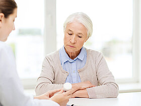 doctor with medicine and senior woman at hospital