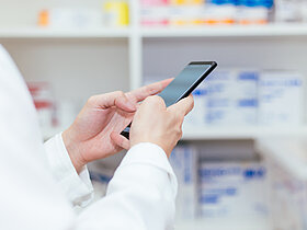 Pharmacist, Physician using a mobile phone at drugstore room. Doctor touching a cell phone in medical concept