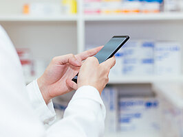 Pharmacist, Physician using a mobile phone at drugstore room. Doctor touching a cell phone in medical concept